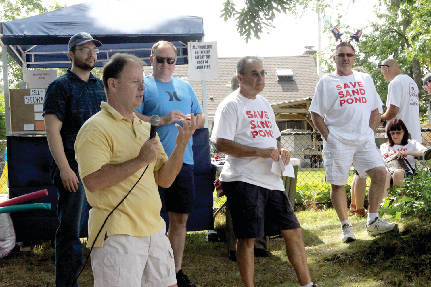 COMMITTED TO FIGHT PLAN: Norwood resident James Desmaris called on neighbors to carry forward their fight against a self-storage unit at Sand Pond Plaza. Looking on are David Bouchard, emcee at Saturday’s Pond Palozza, and Mayor Joseph Solomon.